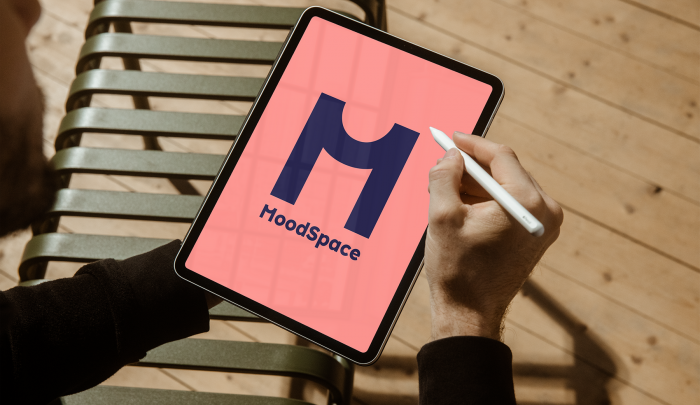 jongere die naar een ipad met logo MoodSpace kijkt jongere die naar een ipad met logo MoodSpace kijkt met pen in de hand